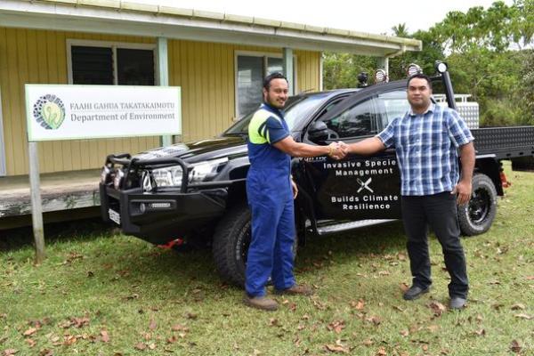 Two Department representatives beside the Niuean invasive-species programme vehicle