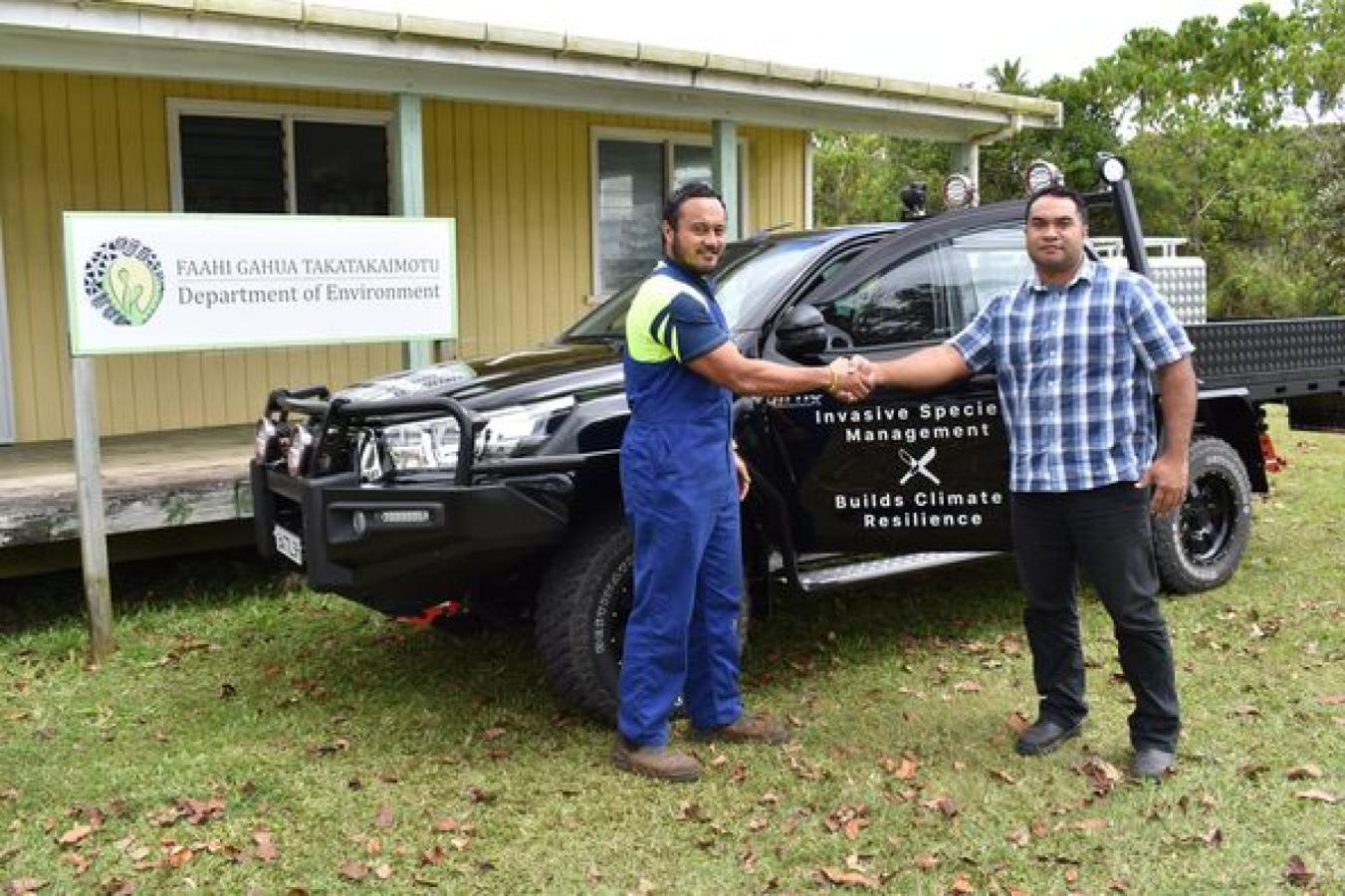 Two Department representatives beside the Niuean invasive-species programme vehicle